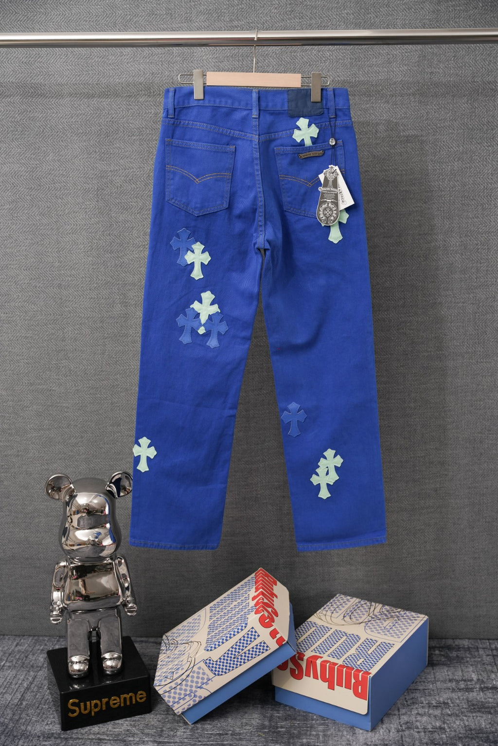 Chrome pants in blue with embroidered cross patches, back pockets, and button fly