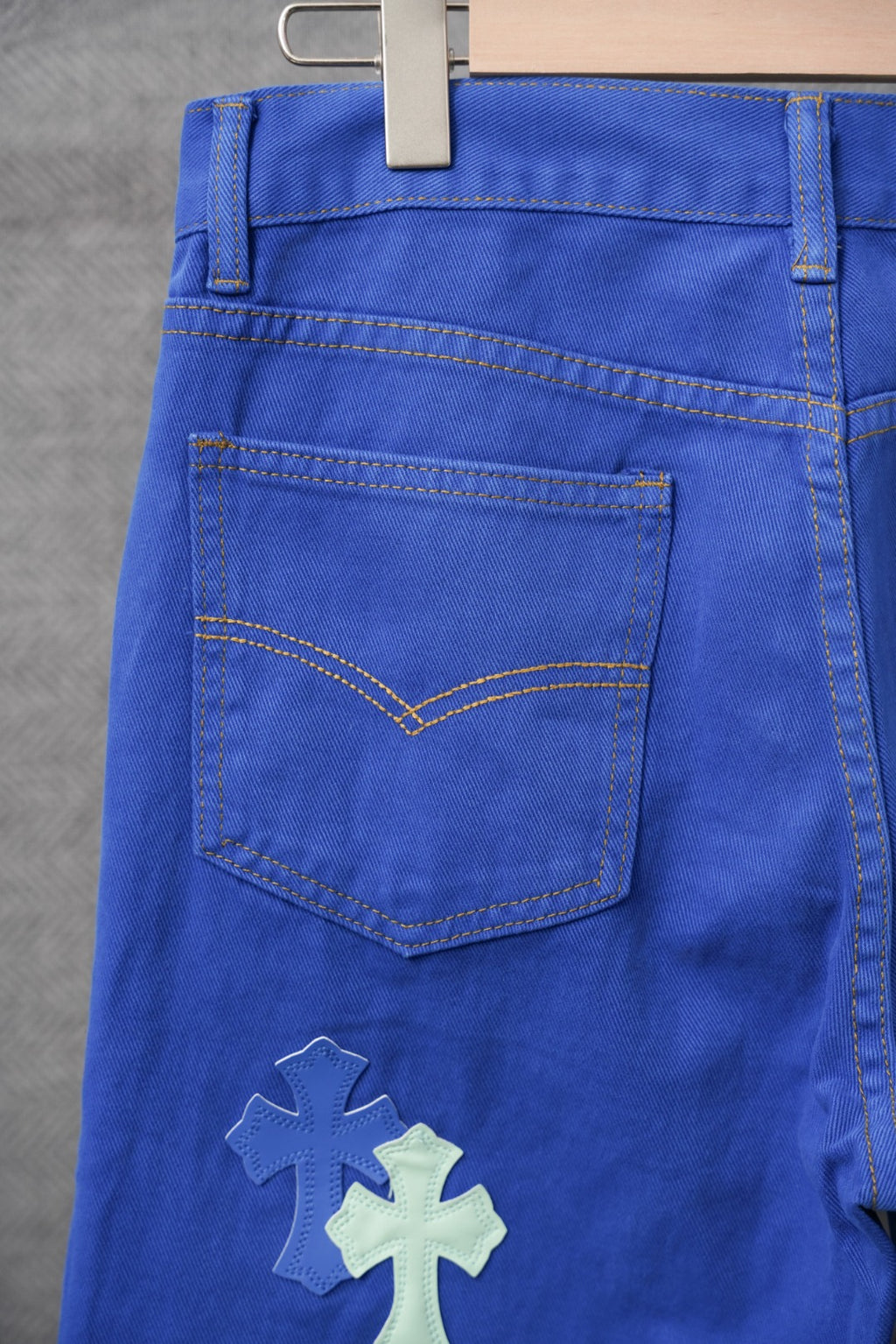 Chrome pants in blue with cross applique, stitched front pocket, and belt loops