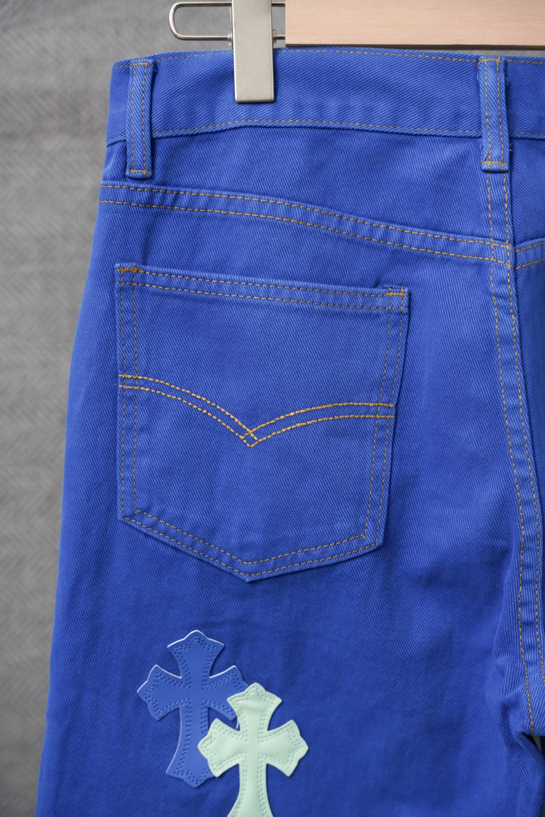Chrome pants in blue with cross applique, stitched front pocket, and belt loops