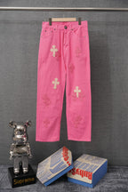 Pink denim pants with cross applique patches and front button closure