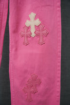 Pink denim pants with three cross appliques on lower front