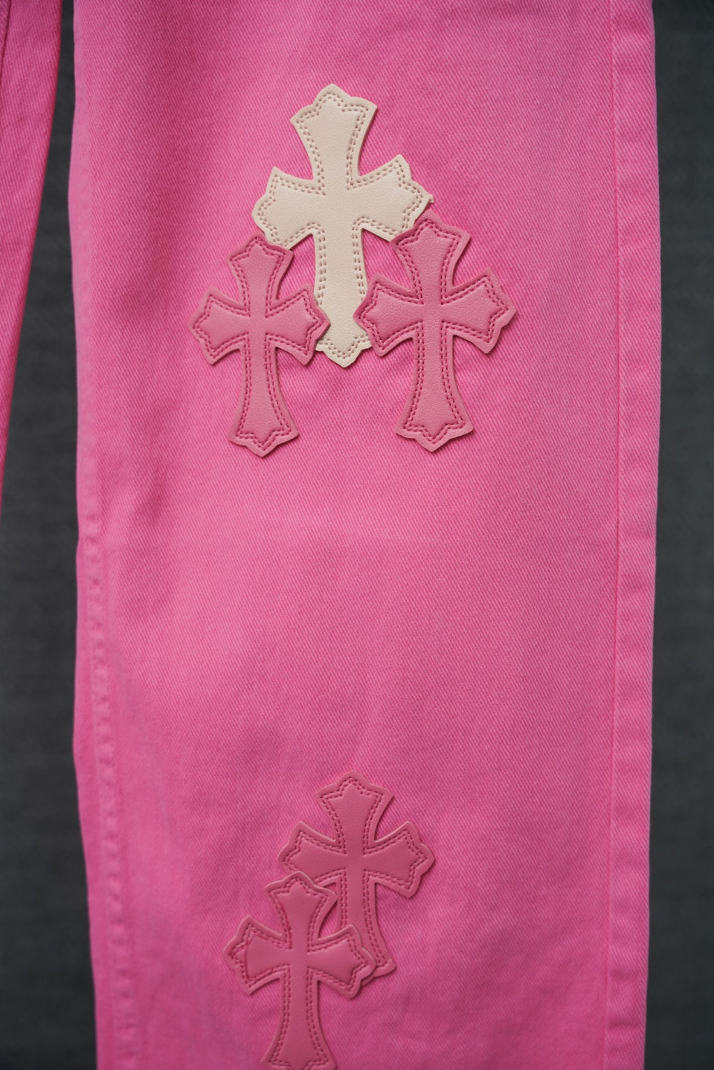 Pink denim pants with three cross appliques on front leg