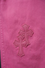 Pink pants with embroidered cross patch on front leg