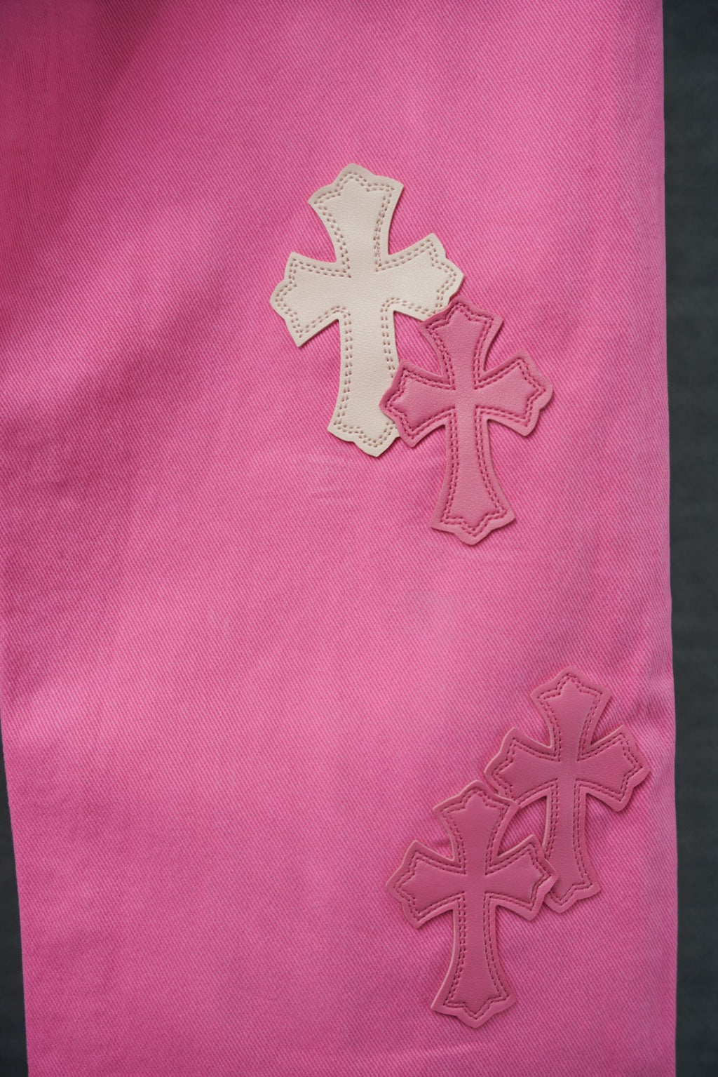 Pink pants leg with stitched cross applique details
