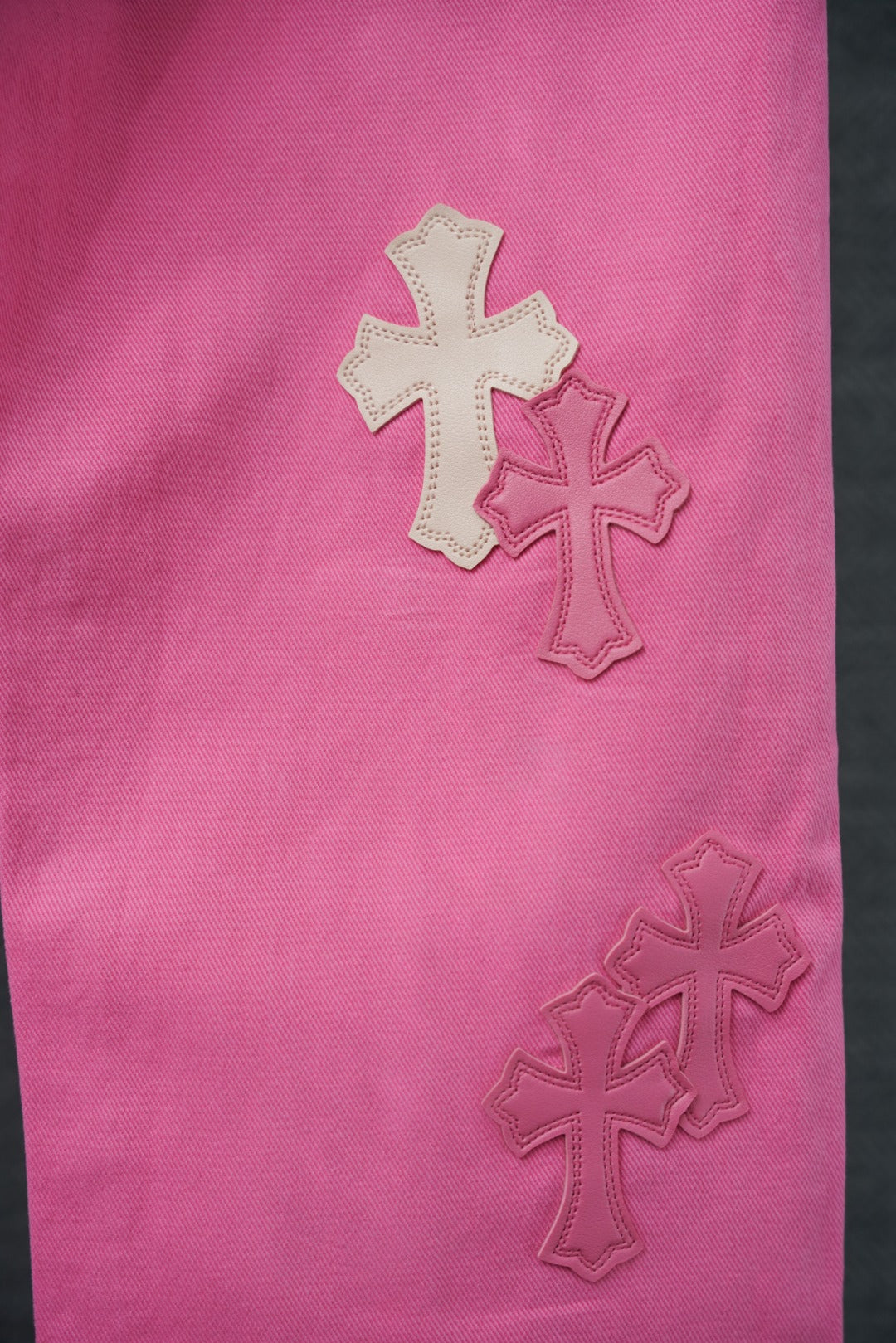 Pink pants leg with stitched cross applique details