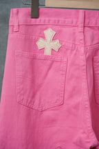 Pink pants waistband and front pocket with large cross applique
