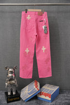 Pink denim pants with cross applique patches and hanging tag on right pocket