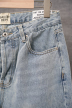 Light wash denim pants front pocket and button fly with white cross tag