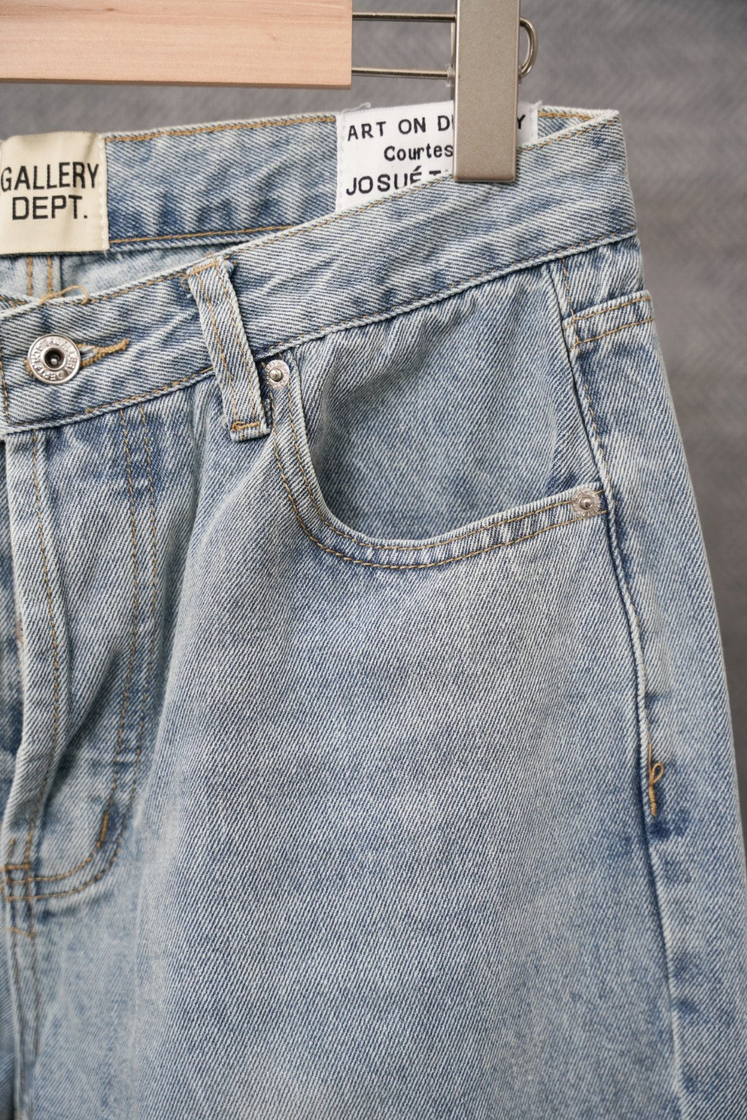 Light blue denim pants with front patch pocket, belt loops, and button fly