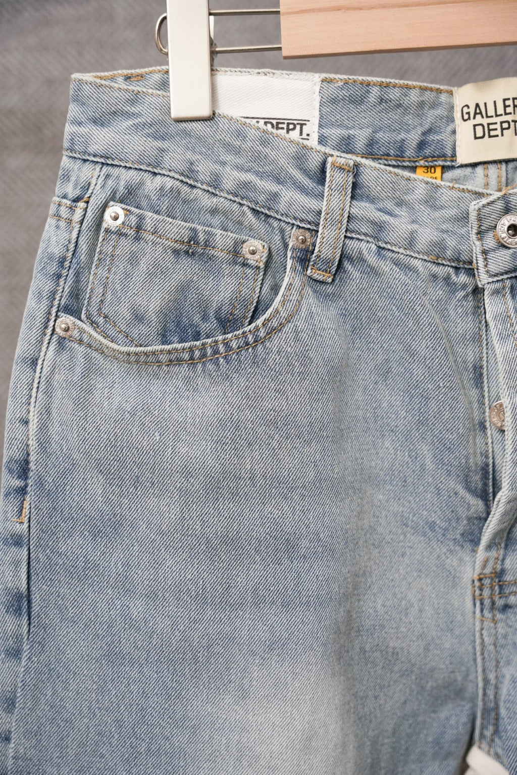 Light wash denim pants back view with belt loops and front patch details