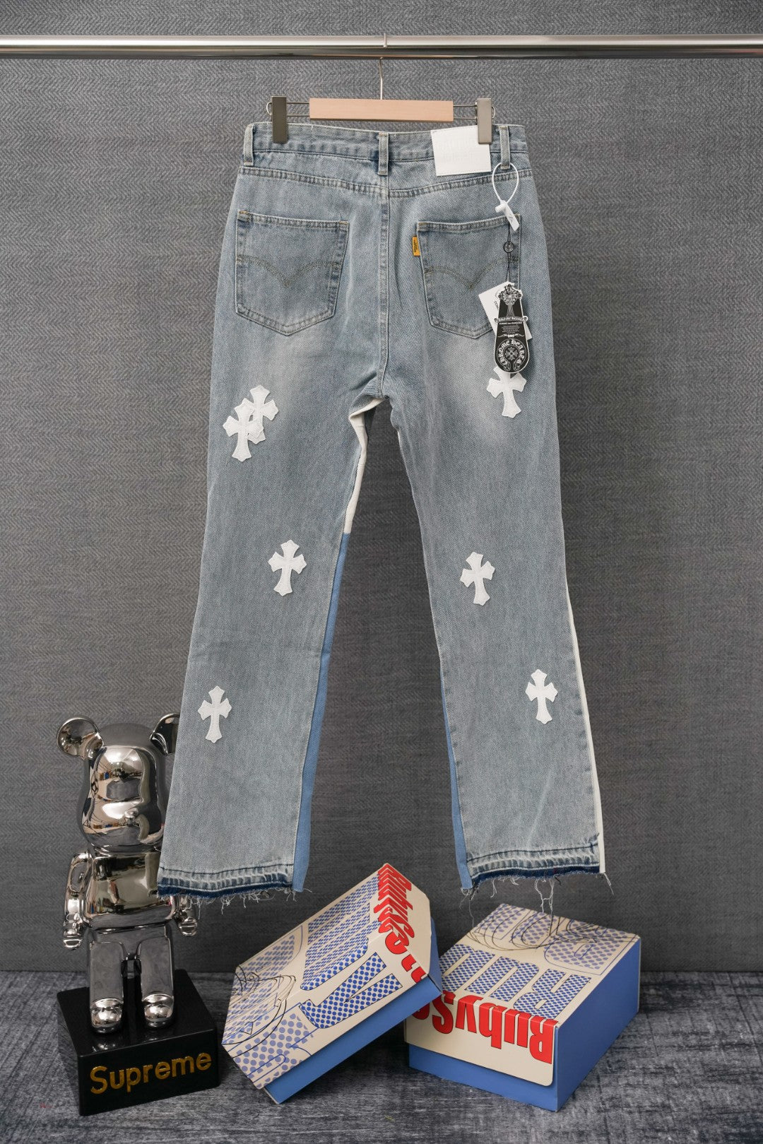 Light wash denim pants with white cross patches and side tag detail