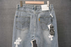 Light wash denim pants with back pockets, keychain charm, and white cross patch