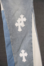 Light wash denim pants with white cross appliques and contrasting side panel