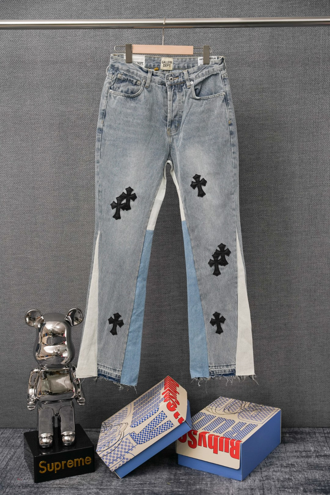 Light blue denim jeans with black cross appliques and patchwork side panels