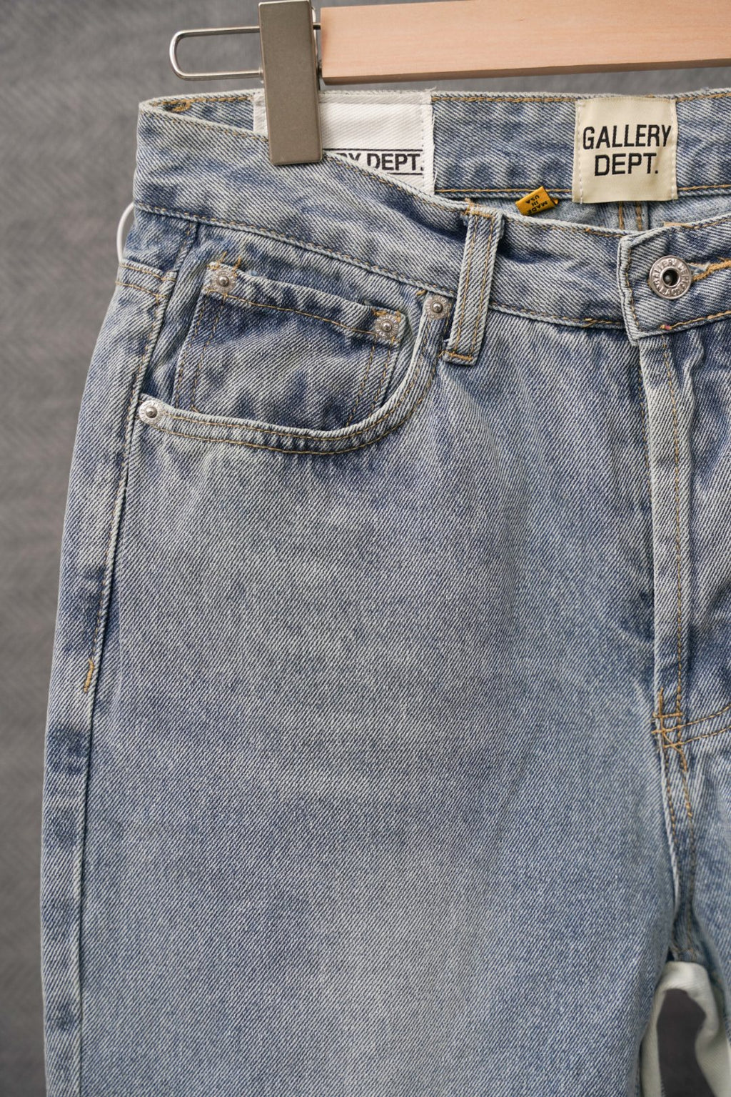 Light wash denim jeans close-up: front patch pocket and button detail