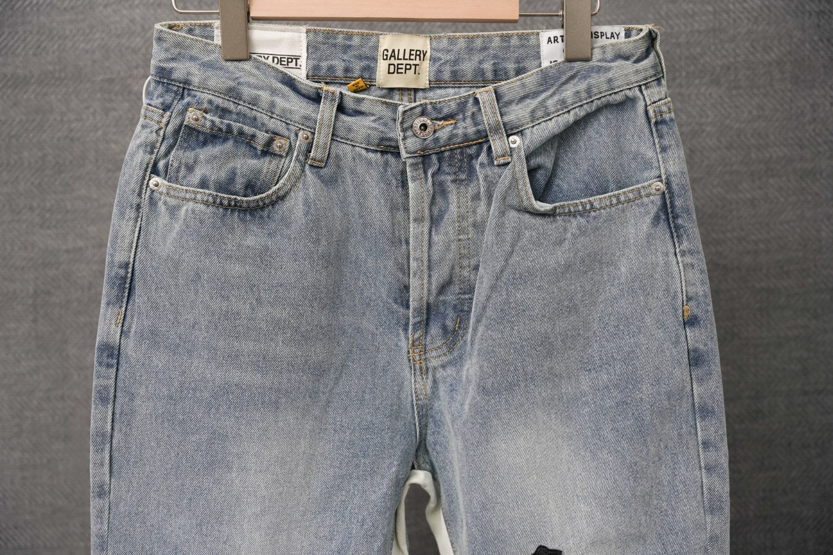Back view of light-wash denim pants with front seam and back pockets
