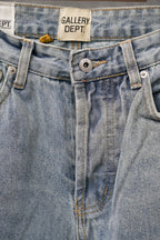 Light wash denim jeans close-up: waistband label and buttoned fly