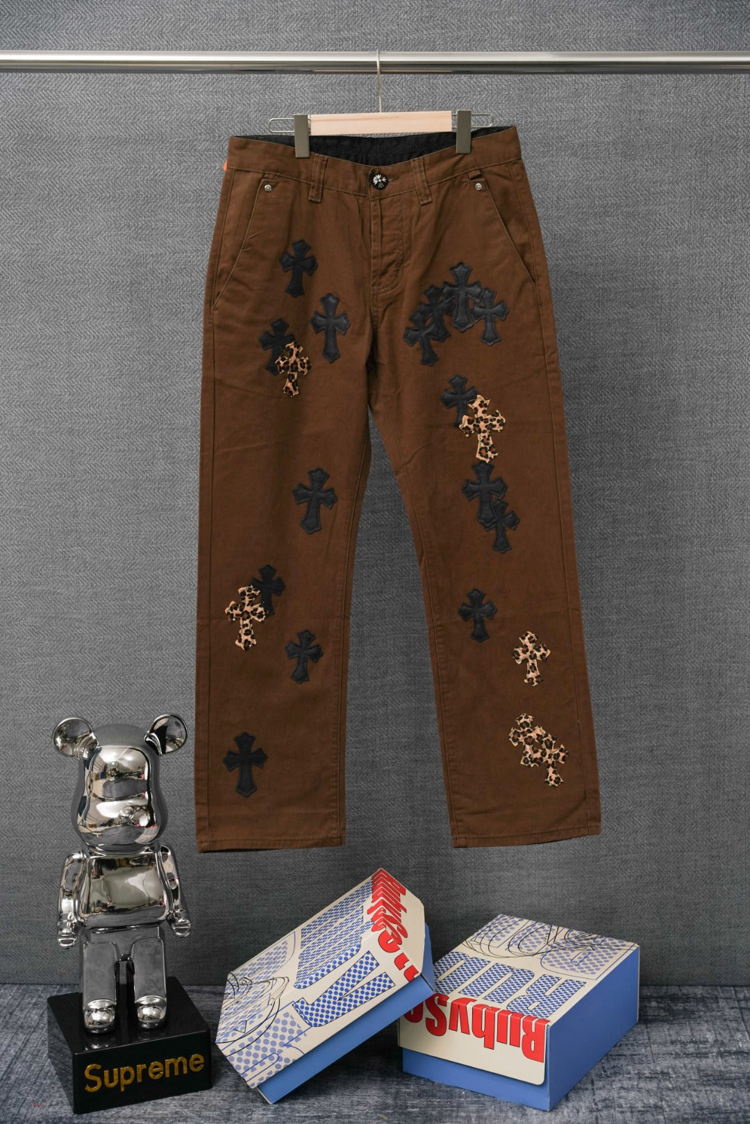 Brown pants with embroidered cross patches and leopard-print cross accents