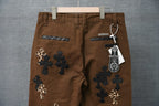 Brown pants with back pockets and cross patches in dark with leopard-print accents