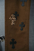Brown pants with dark cross patches and one leopard-print cross applique