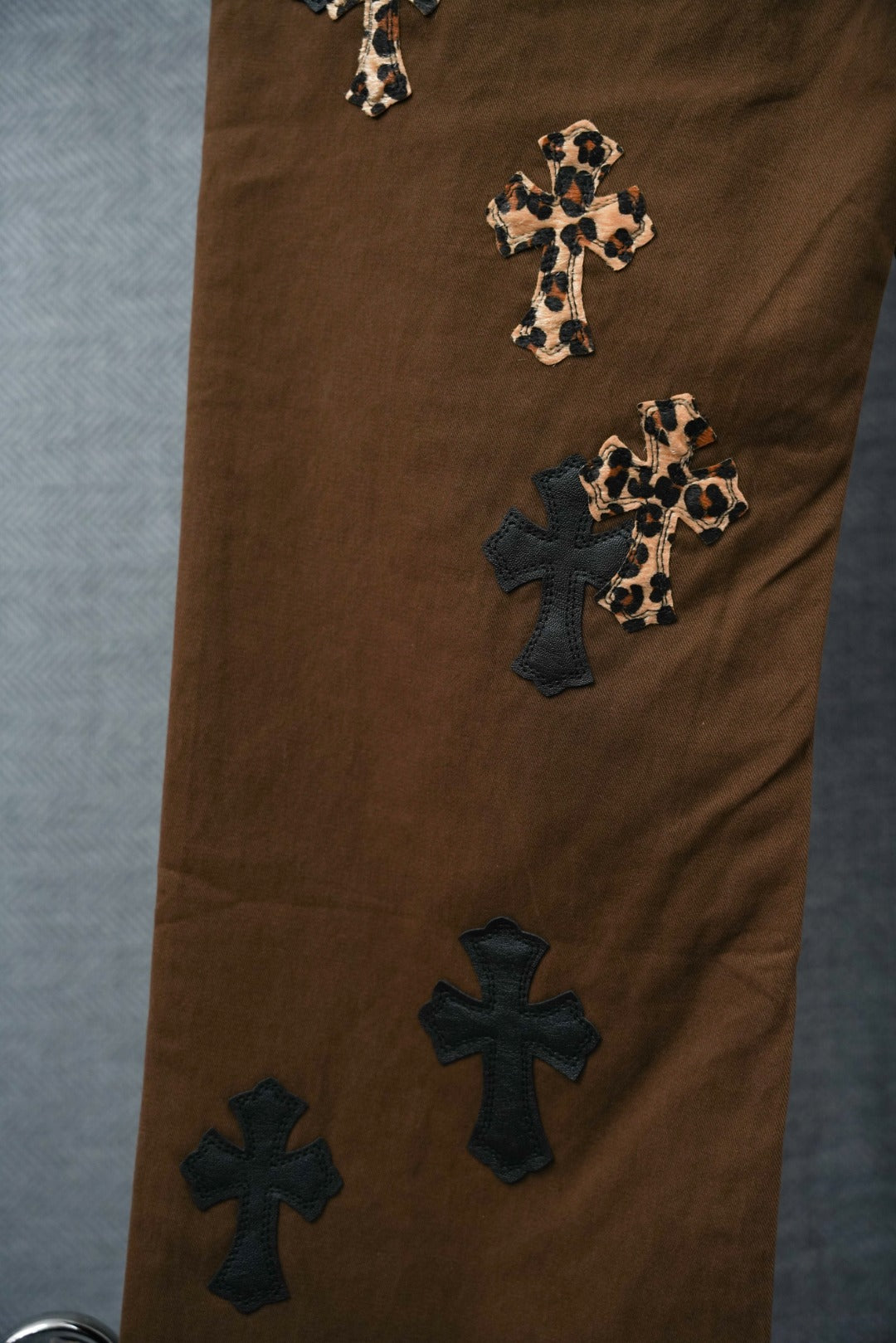 Chrome pants in brown with cross patches on legs and leopard-print accents