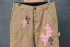 Beige cargo pants front with pink and black cross appliques and button waistband