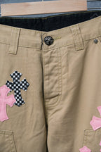 Tan pants waistband with snap button and pink/black check cross patches