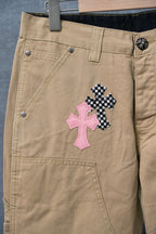 Beige cargo pants with pink and black cross appliques near front pocket