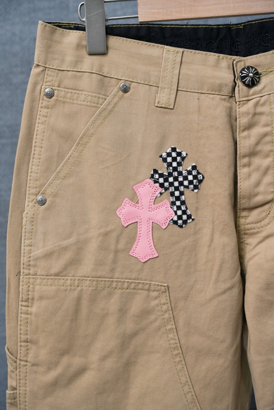 Tan pants with pink and black check cross patch on the thigh, side view