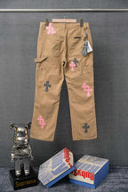 Beige cargo pants with pink and black cross patches, cargo pockets and side strap