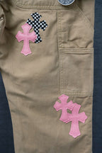 Beige cargo pants with pink and black check cross patches on the front