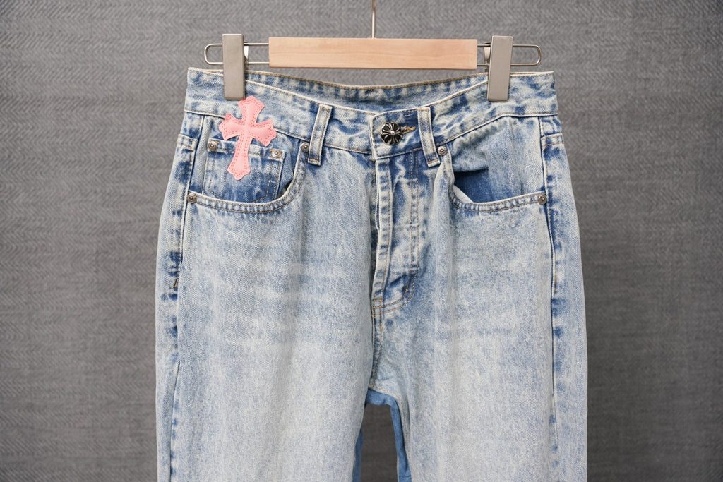 Light blue denim pants with pink cross patch, belt loops, and back pockets