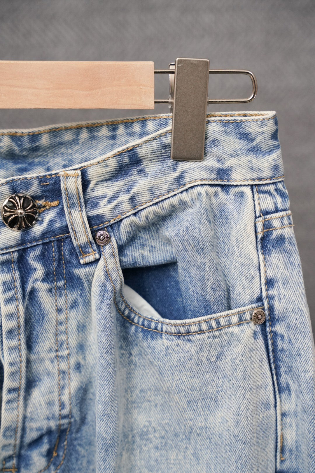Light-wash denim pants with side pocket opening and metal button accents