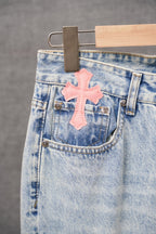 Light blue denim front pocket with pink cross applique and metal button