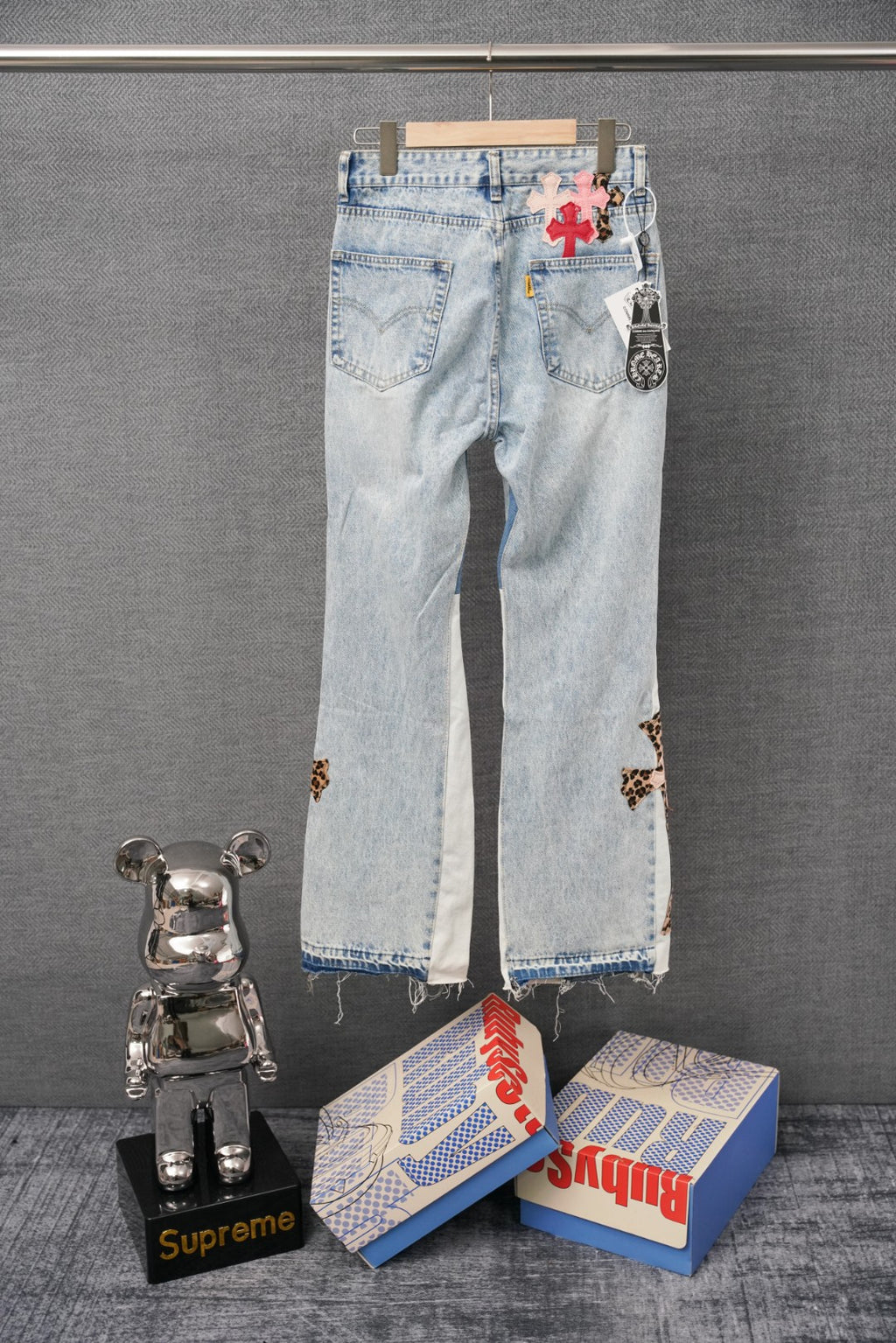 Light-wash denim pants with cross patches and small leopard print accents