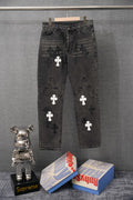 Black denim pants with white and dark cross appliques, front view