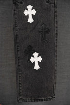 Black denim pants leg with two white cross patches and dark cross motifs