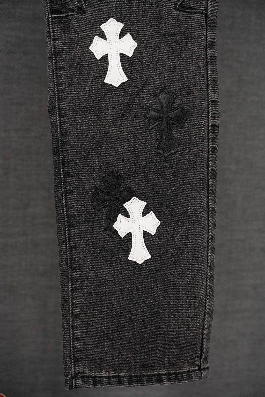 Chrome pants, dark denim close-up of side with multiple cross appliques