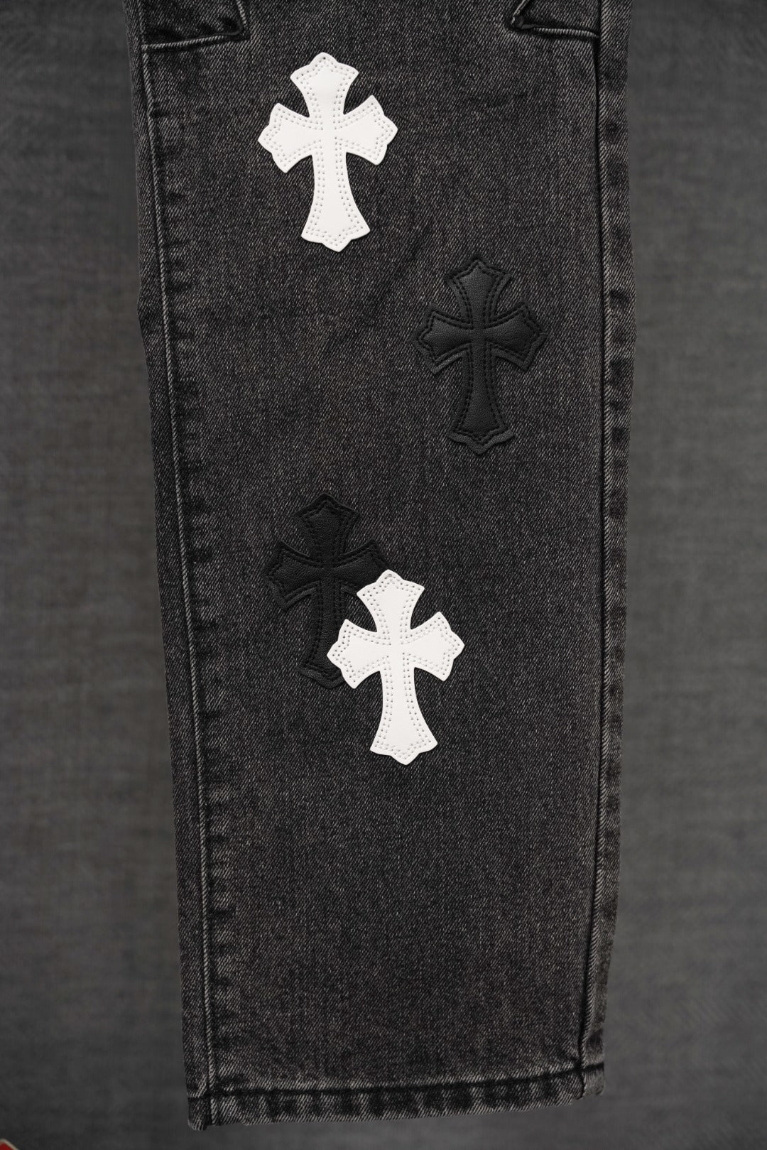 Chrome pants, dark denim close-up of side with multiple cross appliques