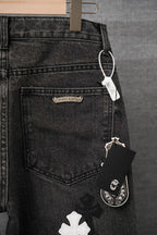 Black denim pants with back pocket detail and hanging tag, white cross patch