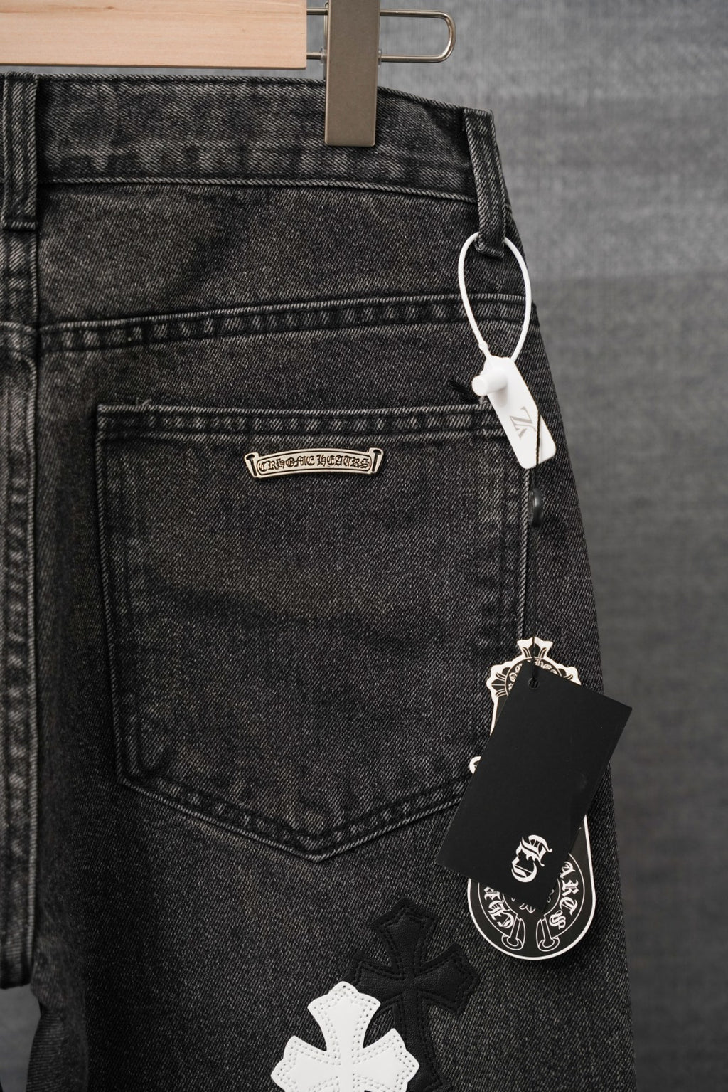 Chrome pants, dark denim pocket with small branded tag and hanging accessory charm