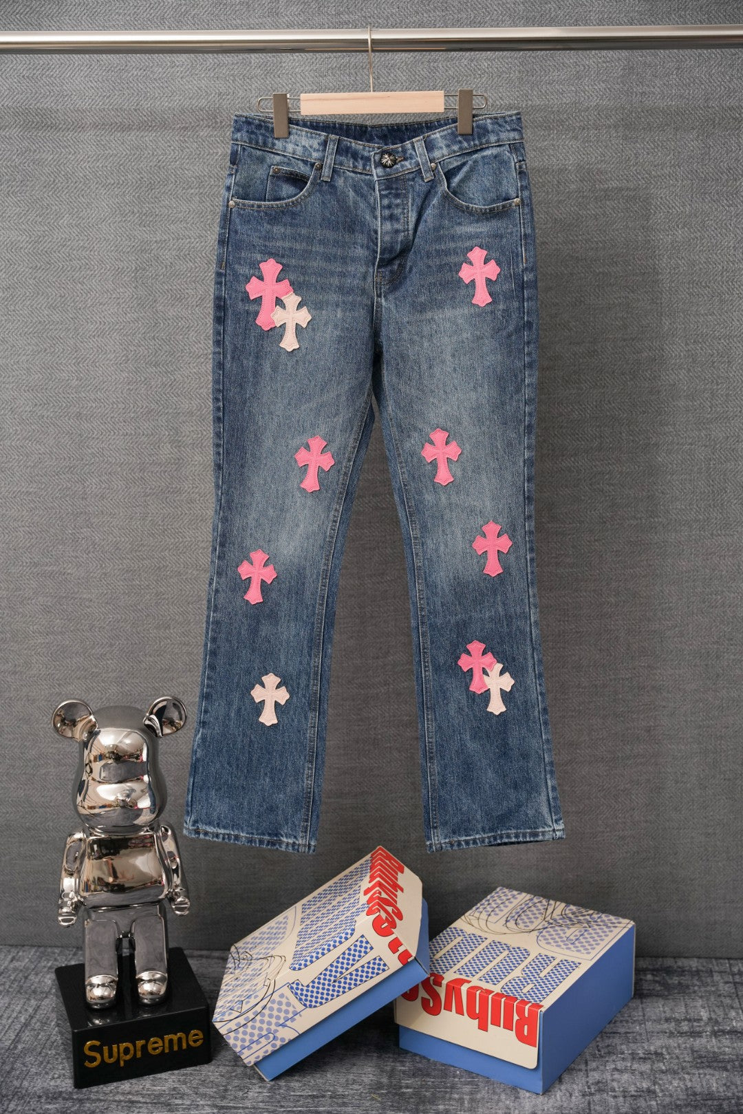 Chrome pants in blue denim with pink cross patches on the front legs