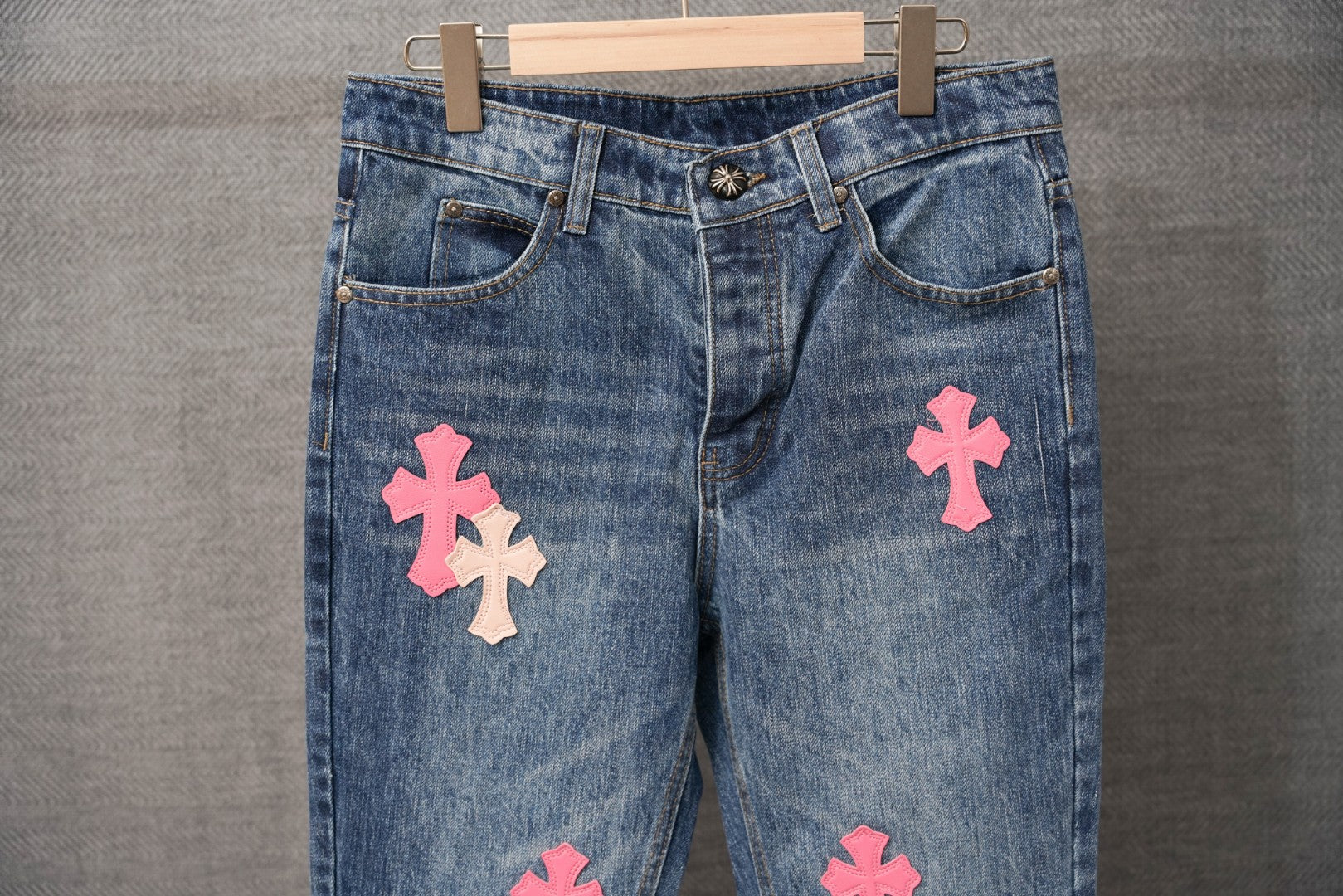 Blue denim Chrome pants, waistband and button with pink cross patches.