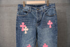 Chrome pants in light blue denim with embroidered pink cross patches on the thighs