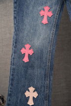 Chrome pants in blue denim with pink and tan cross patches along the side