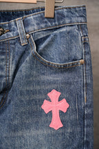 Chrome pants with blue denim pockets and a pink cross patch near the front
