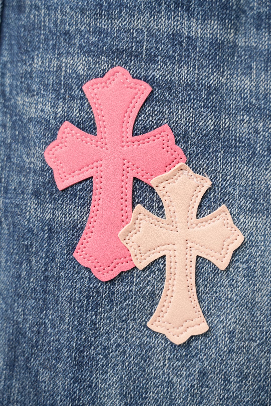 Chrome pants fabric detail with large pink cross patch and tan cross overlay