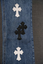 Blue denim pants close-up of vertical seam with multiple cross patches