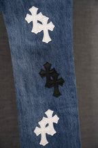 Blue denim pants with spaced cross appliqués on leg