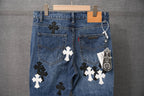 Blue denim pants front view with cross patches and a hanging tag